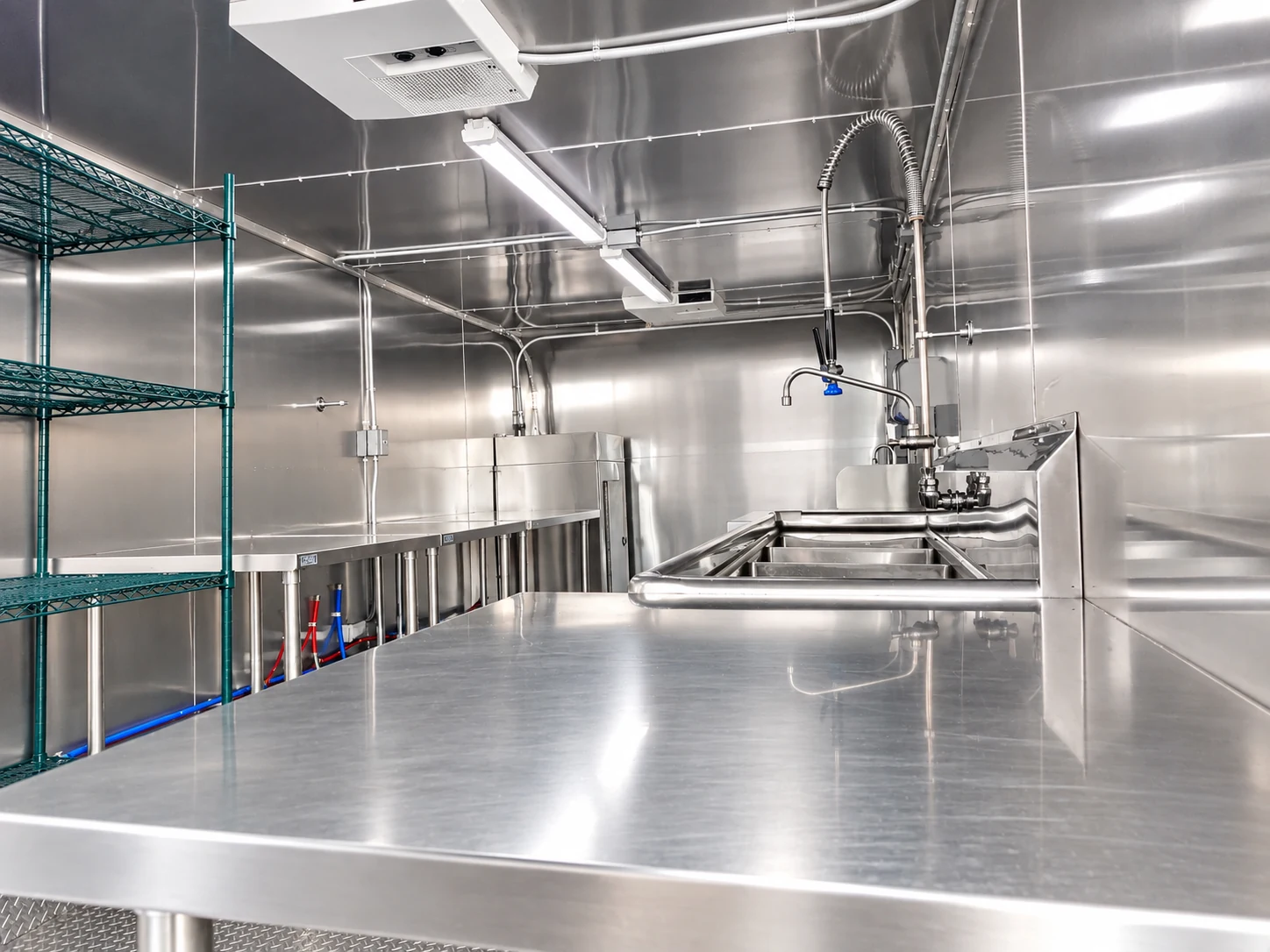 Wide stainless-steel workstation and sinks inside a 22–26 ft low-temperature dishwashing trailer